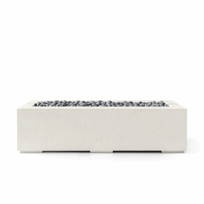 Front product view of the HPC Fire Hearth Products Controls Dekko GFRC Concrete Avera 60 x 26 Fire Pit in Limestone finish featuring Slate Stone media. The rectangular concrete fire pit combines subtle texture, clean geometric styling, and smooth gray decorative stones, offering a sophisticated centerpiece for residential patios, outdoor lounges, and landscape projects.