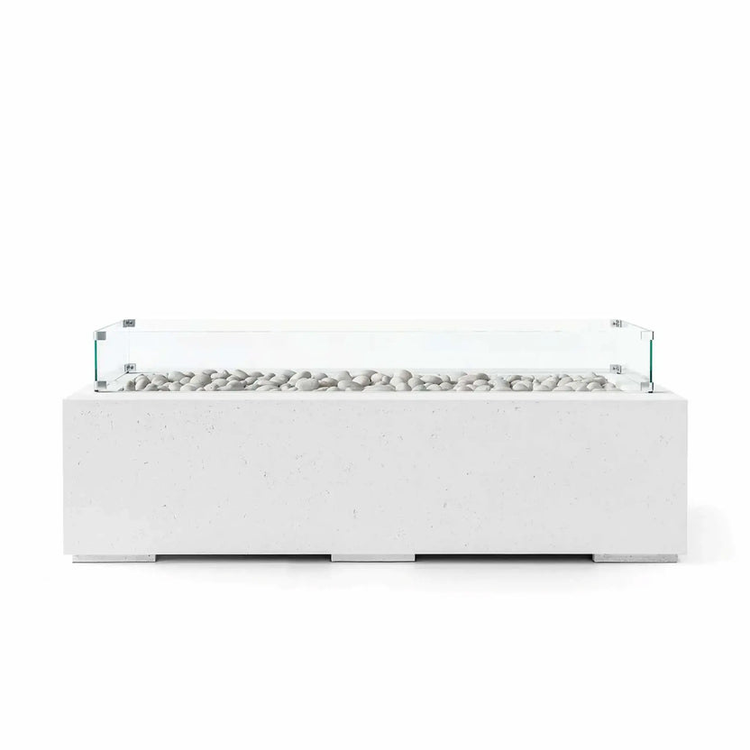 HPC Fire Hearth Products Controls Dekko GFRC Concrete Avera 60 x 26 Fire Pit in Natural finish with smooth ivory fire stones and a tempered glass wind guard. The light-toned rectangular fire pit showcases durable GFRC concrete construction, a streamlined linear burner opening, and a minimalist outdoor design that blends seamlessly into modern patios, courtyards, and outdoor entertaining spaces.