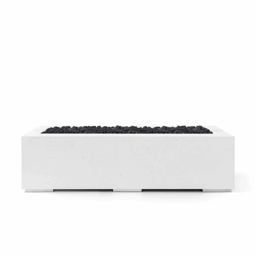 Front-facing studio image of the HPC Fire Hearth Products Controls Dekko GFRC Concrete Avera 60 x 26 Fire Pit in a Natural concrete finish with Lava Rock media. The rectangular outdoor fire pit features durable glass fiber reinforced concrete construction, a recessed linear burner opening, and black volcanic lava rock that contrasts against the light concrete body, creating a clean, contemporary centerpiece for patios and outdoor living spaces.