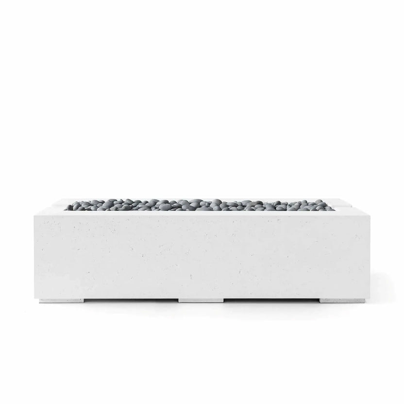 HPC Fire Hearth Products Controls Dekko GFRC Concrete Avera 60 x 26 Fire Pit shown in Natural finish with Slate Stone fire media. This modern rectangular fire feature combines a textured concrete exterior with smooth gray decorative stones arranged across the burner tray, offering a refined architectural appearance suited for luxury patios, outdoor lounges, and landscape design projects.
