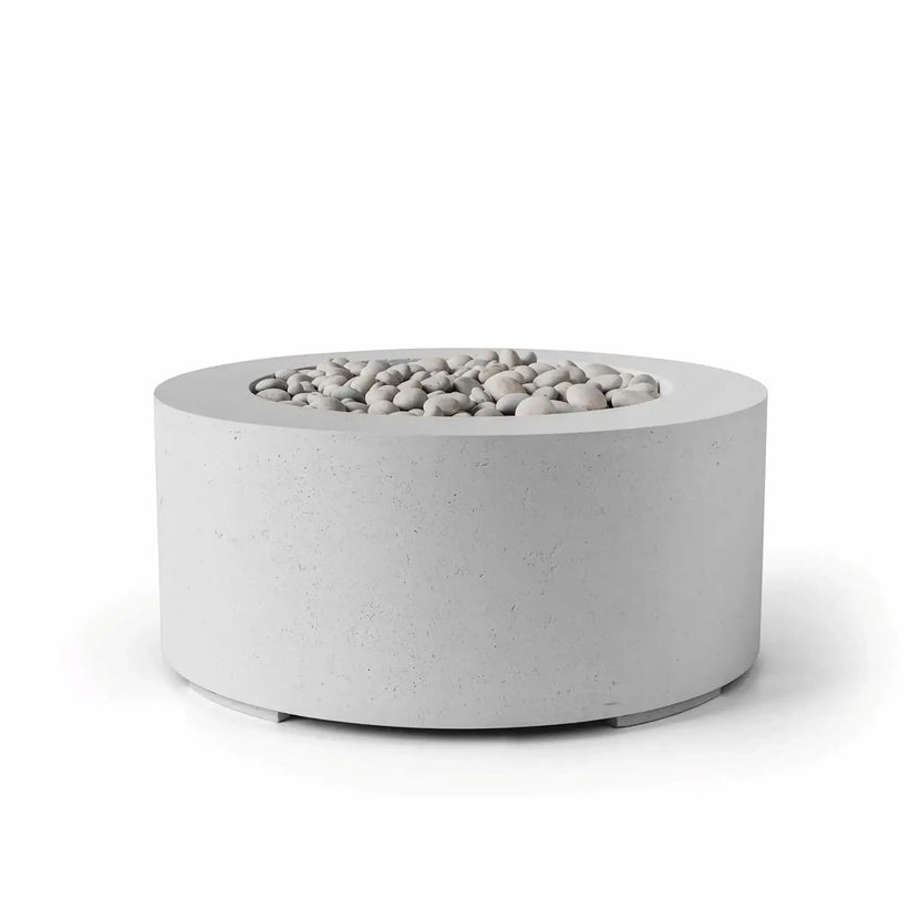 HPC Fire Hearth Products Controls Dekko GFRC Concrete Belmont Fire Pit in Ash finish featuring a modern 36-inch round GFRC concrete fire pit design. The recessed burner area is filled with smooth ivory stone media, creating a clean and contemporary appearance. Shown on a white background, this low-profile outdoor gas fire pit highlights the textured concrete surface, wide fire bowl rim, and minimalist architectural styling for patios, outdoor living spaces, and commercial landscapes.