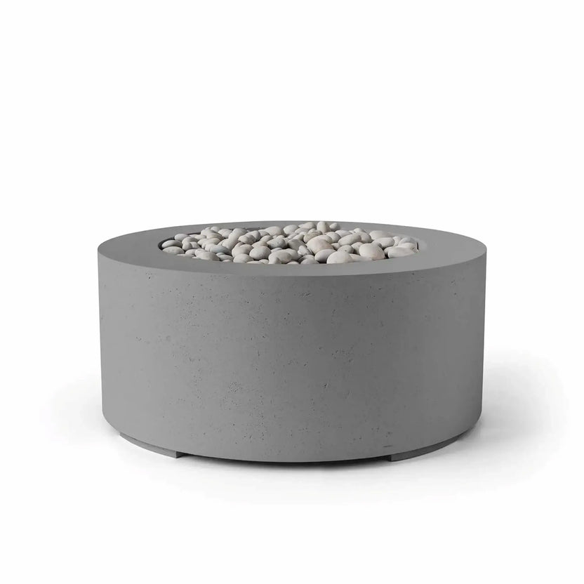 HPC Fire Hearth Products Controls Dekko GFRC Concrete Belmont Fire Pit in Charcoal finish with ivory stone fire media. This contemporary round fire pit features a dark charcoal concrete exterior, wide circular top, and recessed fire bowl filled with smooth decorative stones. The contrasting colors emphasize the modern GFRC construction and minimalist outdoor design, making it ideal for patios, decks, courtyards, and luxury outdoor living spaces.