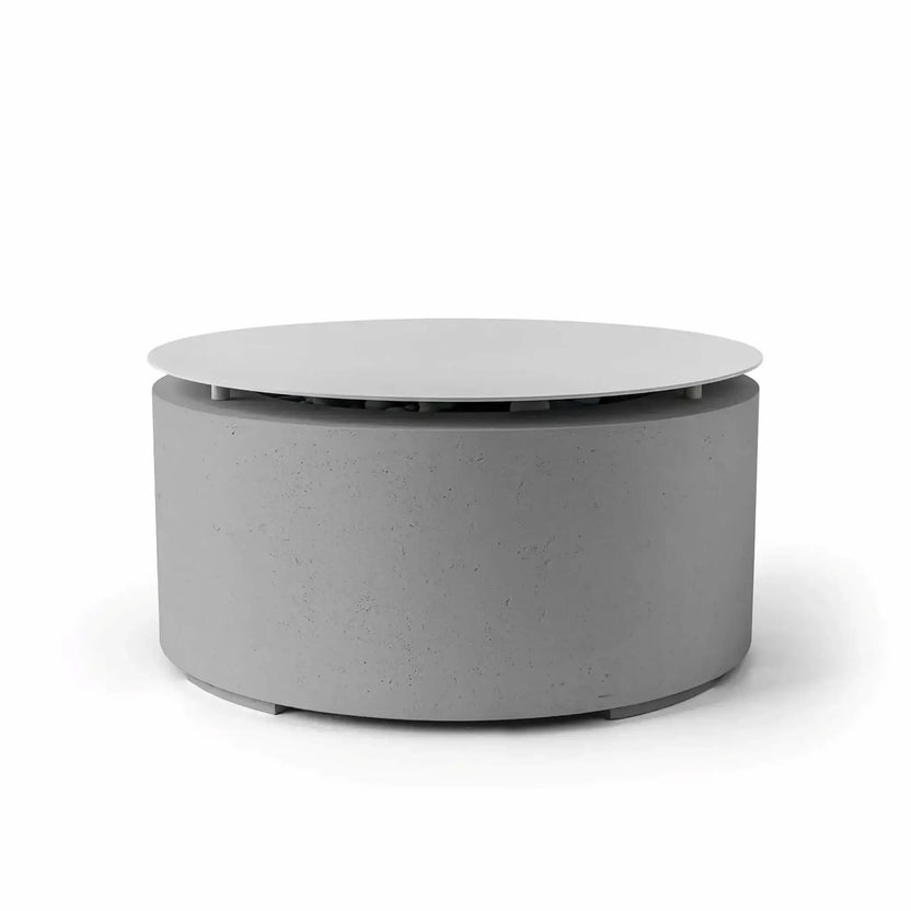 HPC Fire Hearth Products Controls Dekko GFRC Concrete Belmont Fire Pit in Charcoal finish with optional Table Top Lid. The modern round fire pit showcases a dark gray GFRC concrete exterior paired with a circular protective lid elevated above the burner opening. Designed for versatility, the Belmont Fire Pit easily transitions from a fire feature to a practical outdoor coffee table, making it ideal for contemporary patios and gathering spaces.
