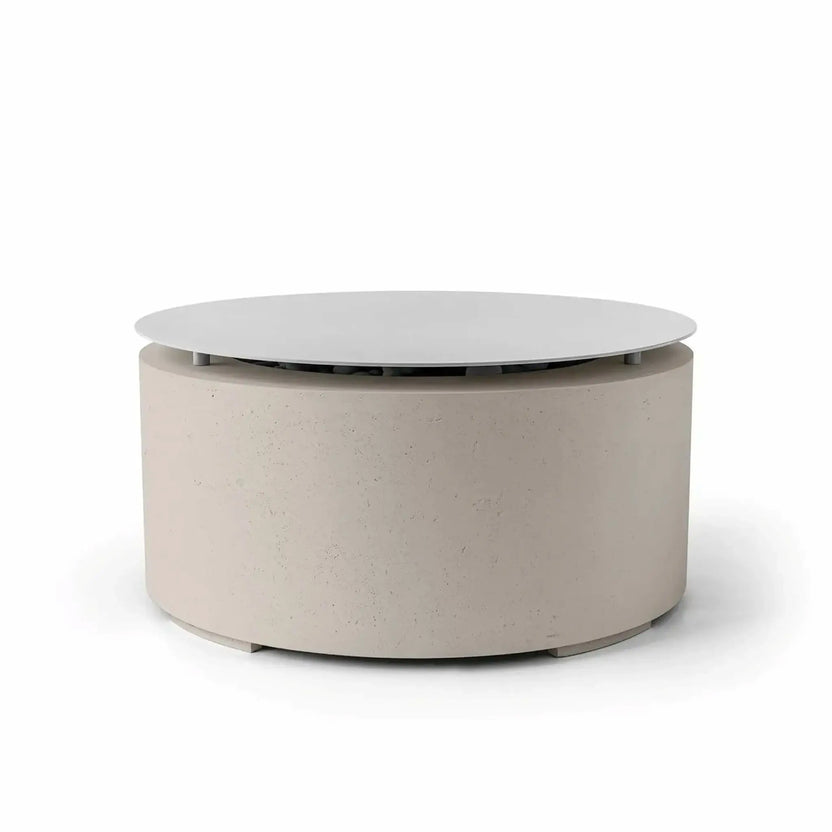 HPC Fire Hearth Products Controls Dekko GFRC Concrete Belmont Fire Pit in Clay finish featuring a matching Table Top Lid. This contemporary round fire pit includes a warm beige concrete body, smooth cylindrical profile, and a circular lid that covers the burner area to create additional tabletop space. The Belmont Fire Pit blends modern outdoor design with practical functionality for residential patios, decks, and entertaining areas.