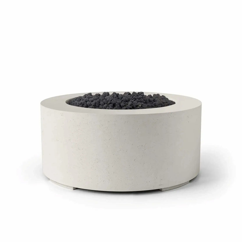 HPC Fire Hearth Products Controls Dekko GFRC Concrete Belmont Fire Pit in Limestone finish with black lava rock media. The round GFRC concrete fire pit combines a light limestone-toned exterior with rugged dark volcanic rock for striking visual contrast. Its low-profile cylindrical design, durable construction, and modern styling make the Belmont Fire Pit ideal for residential patios, rooftop decks, and commercial outdoor environments.