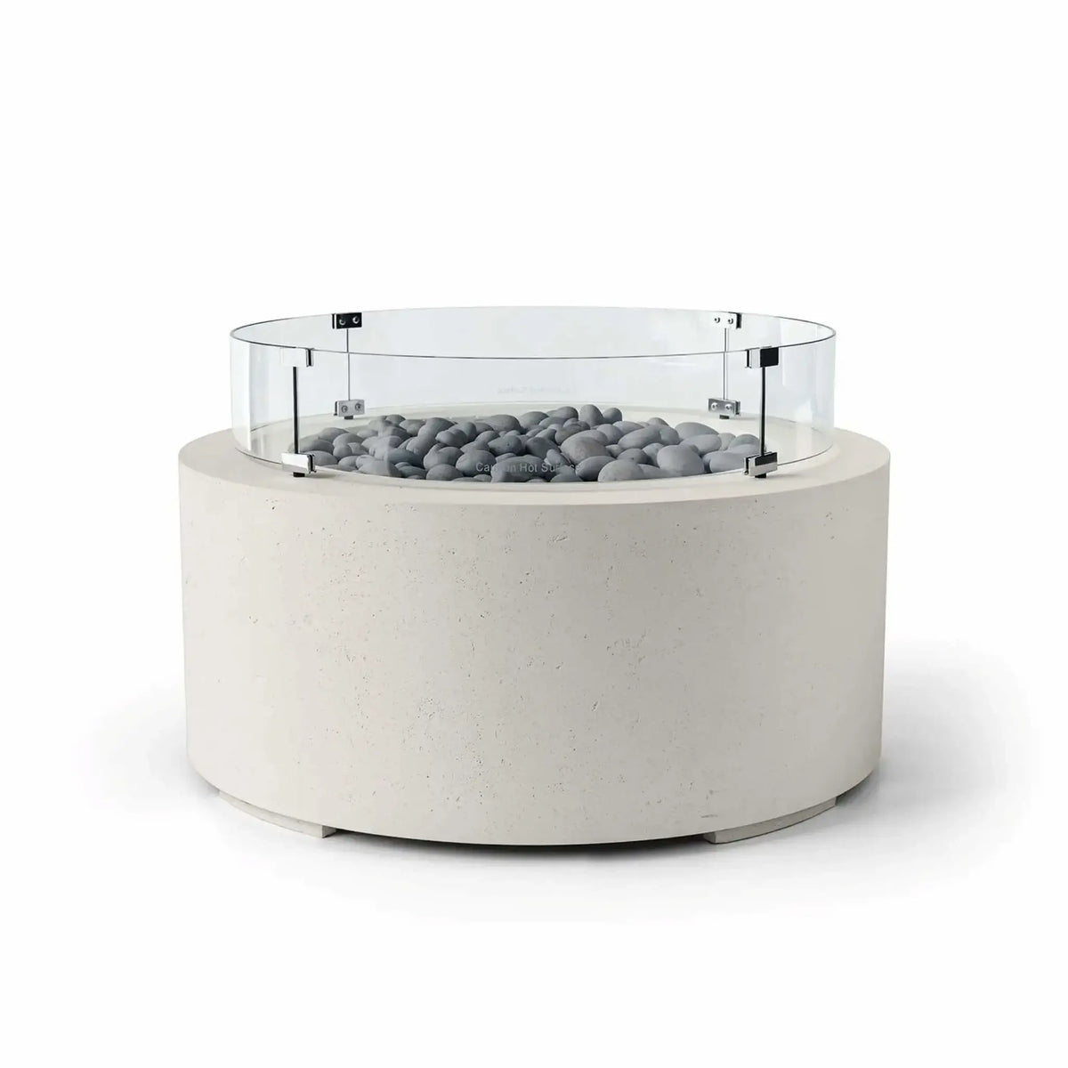 HPC Fire Hearth Products Controls Dekko GFRC Concrete Belmont Fire Pit in Limestone finish featuring Slate Stone fire media and a Tempered Glass Wind Guard. This contemporary round fire pit showcases a light limestone-colored concrete body, smooth gray slate stones around the burner area, and a transparent circular glass windscreen supported by metal hardware. The minimalist design makes the Belmont Fire Pit an elegant addition to modern outdoor entertaining areas.
