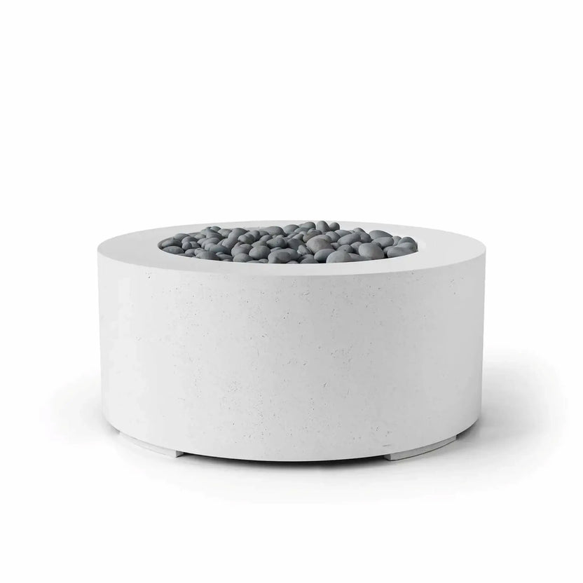 HPC Fire Hearth Products Controls Dekko GFRC Concrete Belmont Fire Pit in Natural finish showcasing decorative slate stone media. This round GFRC concrete fire pit features a soft white concrete appearance, wide top ledge, and recessed fire bowl filled with smooth gray slate stones. The Belmont Fire Pit’s clean lines and modern architectural form make it an elegant addition to contemporary patios, courtyards, hospitality environments, and outdoor entertainment areas.