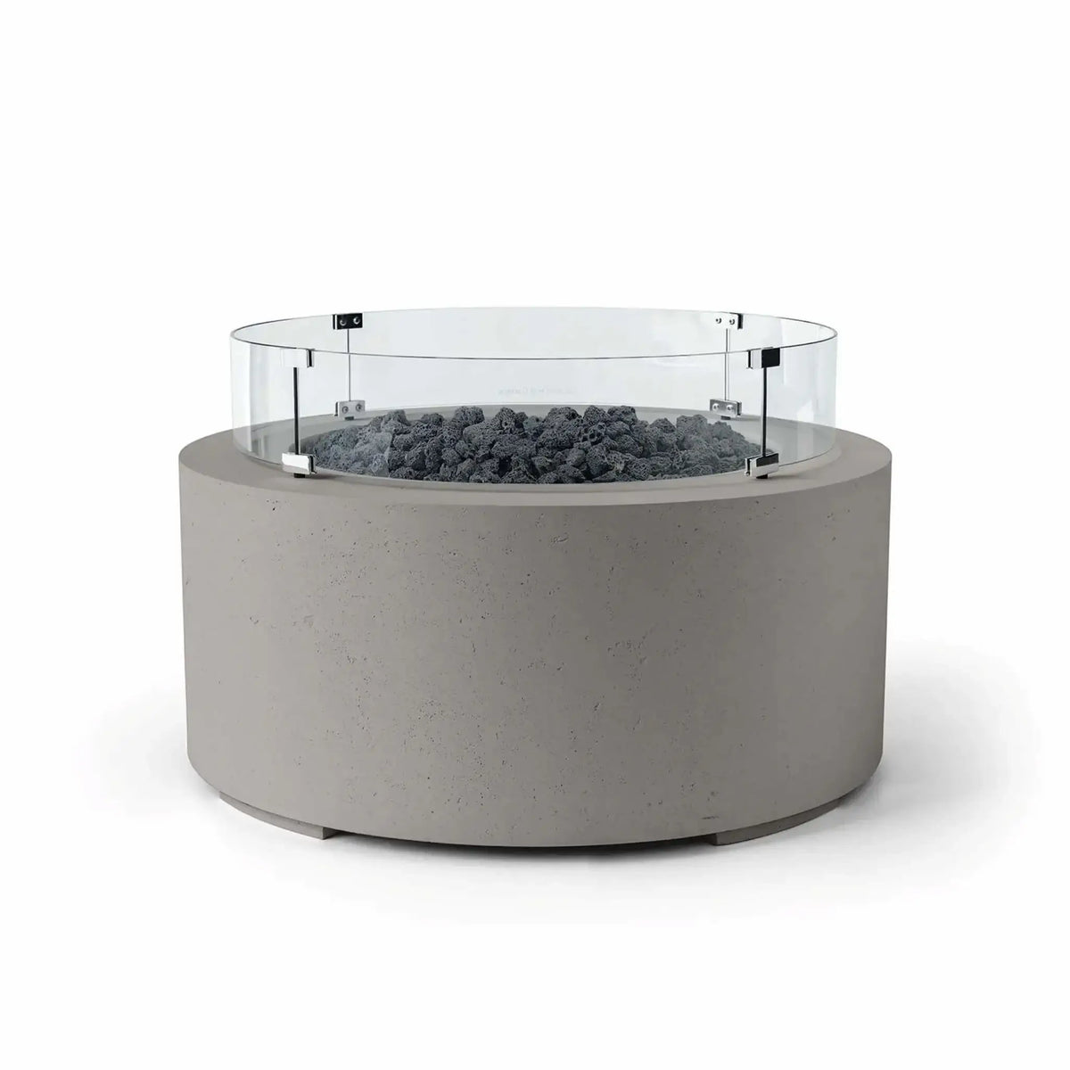 HPC Fire Hearth Products Controls Dekko GFRC Concrete Belmont Fire Pit in Sandstone finish featuring Lava Rock media and a Tempered Glass Wind Guard. The round fire pit showcases a textured sandstone-colored GFRC concrete exterior, dark volcanic lava rock fire media, and a transparent circular windscreen mounted with stainless steel brackets. The Belmont Fire Pit offers a sophisticated blend of natural textures and contemporary outdoor styling.