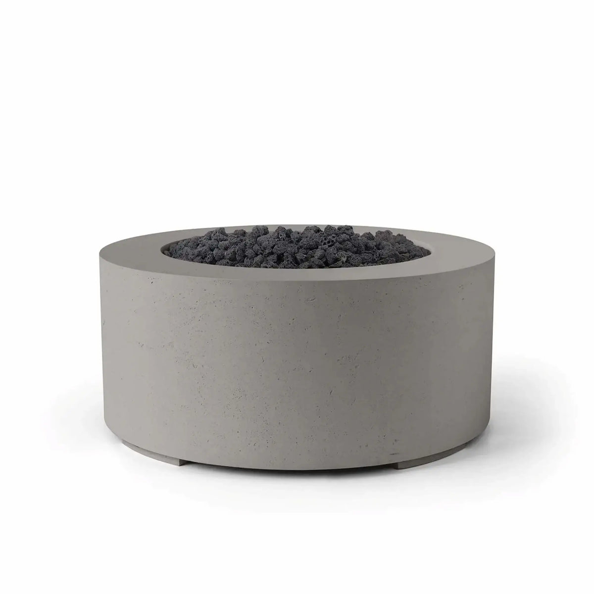 HPC Fire Hearth Products Controls Dekko GFRC Concrete Belmont Fire Pit in Sandstone finish featuring black lava rock media. The round outdoor fire pit showcases a textured GFRC concrete body, broad circular rim, and recessed fire area filled with rugged volcanic rock. The warm sandstone finish paired with dark lava rock creates a bold contemporary look, making the Belmont Fire Pit an attractive focal point for patios, outdoor lounges, and commercial landscapes.