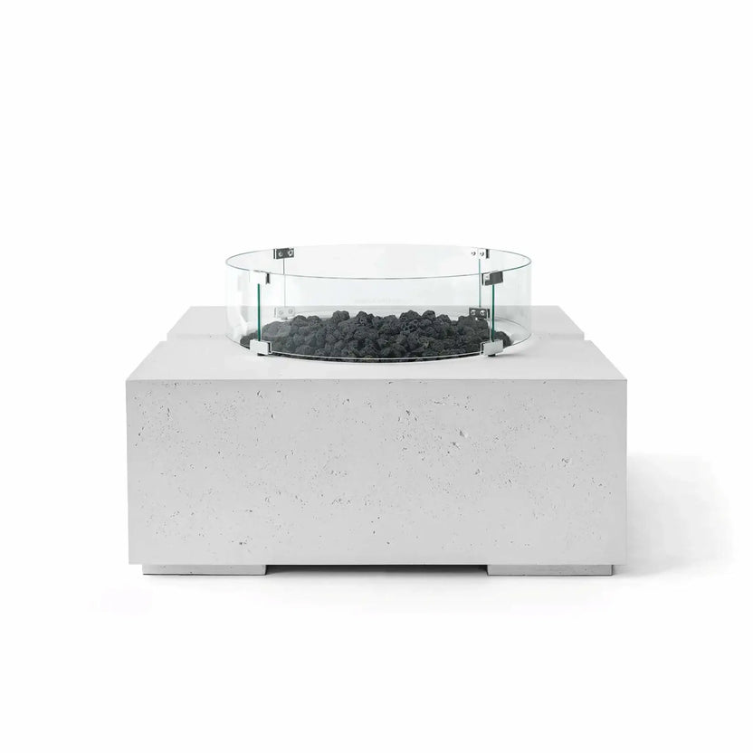 HPC Fire Hearth Products Controls Dekko GFRC Concrete Bravo 32 x 32 Fire Pit in Ash finish with natural black lava rock fire media and a circular tempered glass wind guard. The square concrete fire pit features a textured GFRC construction, elevated burner platform, and minimalist outdoor styling, shown in a front-facing product image against a clean white backdrop.