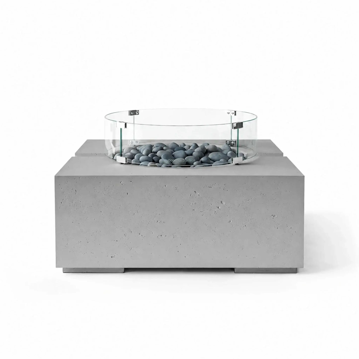 HPC Fire Hearth Products Controls Dekko GFRC Concrete Bravo 32 x 32 Fire Pit in Charcoal finish with Slate Stone fire media and a tempered glass wind guard. The dark concrete base and smooth gray stones create a sleek contemporary look, while the circular glass guard surrounds the burner area, emphasizing safety and modern outdoor design.