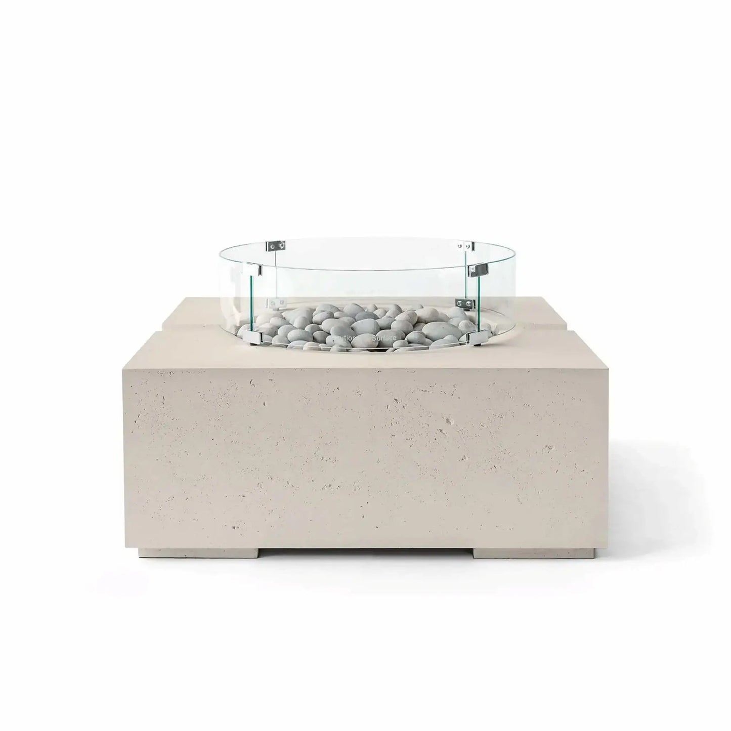 HPC Fire Hearth Products Controls Dekko GFRC Concrete Bravo 32 x 32 Fire Pit in Clay finish featuring Ivory Stone fire media and a tempered glass wind guard. The warm beige concrete tone complements the smooth light-colored stones, creating an elegant modern fire feature with a textured GFRC construction and clean-lined square silhouette.