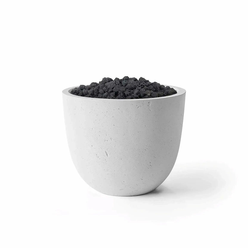 HPC Dekko GFRC Concrete Element 20 Round Fire Column featuring an Ash concrete finish paired with natural black lava rock media. The rounded fire column has a sleek, modern silhouette with a textured gray GFRC concrete exterior and a recessed burner area filled with porous volcanic rock. Studio-style product image on a white background emphasizing the Ash and Lava Rock fire feature combination.
