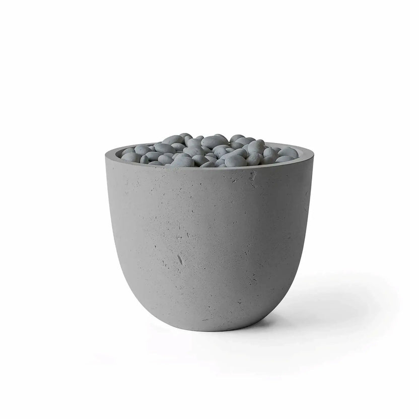 Dekko GFRC Concrete Element 20 Round Fire Column by HPC in a Charcoal finish with Slate Stone decorative media. The modern fire column combines a dark gray GFRC concrete body with polished gray stones surrounding the burner area. Studio product image on a white background highlighting the rounded silhouette, textured concrete surface, and contemporary outdoor fire feature styling.
