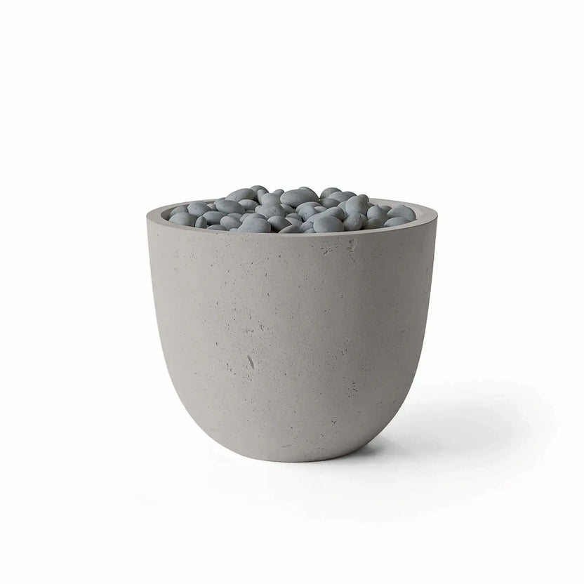 HPC Fire Hearth Products Controls Dekko GFRC Concrete Element 20 Round Fire Column featuring a Sandstone finish and Slate Stone media. The rounded outdoor fire feature combines a warm beige GFRC concrete body with smooth gray slate stones filling the burner opening. Clean product photography on a white background emphasizes the Sandstone concrete texture, contemporary shape, and decorative Slate Stone fire media.