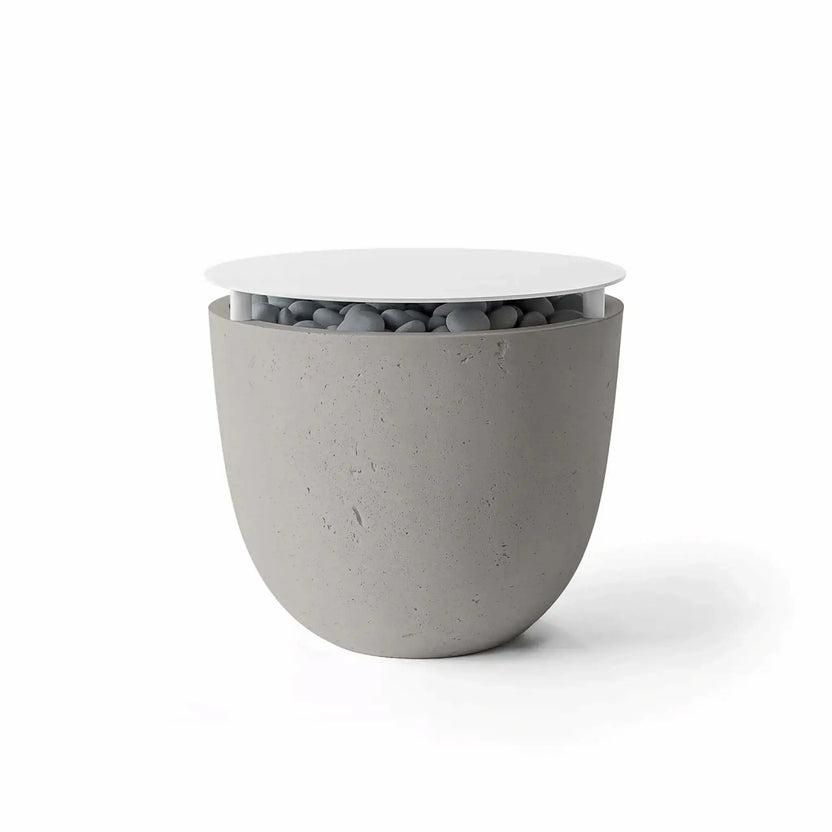 Dekko GFRC Concrete Element 20 Round Fire Column Sandstone Table Top Lid by HPC Fire Hearth Products Controls featuring a soft sandstone-colored concrete finish and matching circular lid. Gray decorative stones are partially visible beneath the tabletop cover, showcasing the fire feature’s dual-purpose functionality. The rounded form and natural texture make this fire column an attractive addition to contemporary outdoor seating and entertaining areas.