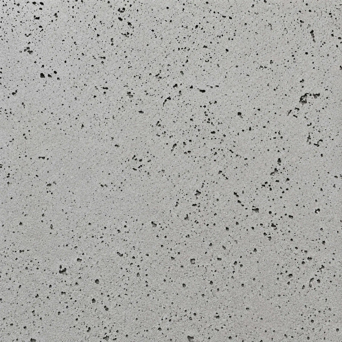 Close-up swatch of HPC Fire Hearth Products Dekko GFRC Concrete Fire Pit Charcoal finish, showcasing a medium gray concrete surface accented by darker pores and natural texture variations. The contemporary charcoal finish delivers a refined industrial look suitable for modern outdoor fire pits, gas fire tables, and custom backyard fire feature designs.