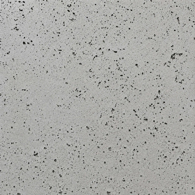 Close-up swatch of HPC Fire Hearth Products Dekko GFRC Concrete Fire Pit Charcoal finish, showcasing a medium gray concrete surface accented by darker pores and natural texture variations. The contemporary charcoal finish delivers a refined industrial look suitable for modern outdoor fire pits, gas fire tables, and custom backyard fire feature designs.