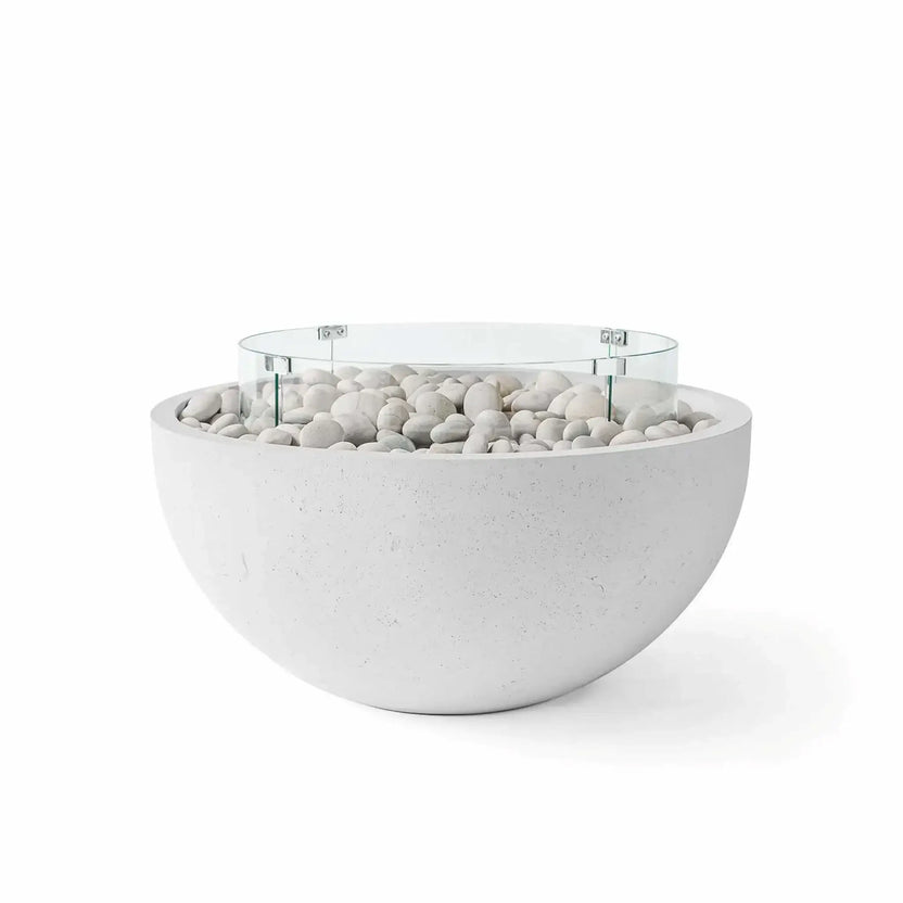 HPC Fire Hearth Products Controls Dekko GFRC Concrete Serenade 32 Fire Pit in Ash finish featuring smooth ivory fire stones and a round tempered glass wind guard. This contemporary bowl-style outdoor gas fire pit showcases a durable GFRC concrete construction with a clean minimalist design, rounded profile, and decorative white stone media for modern patio, backyard, and outdoor living spaces.