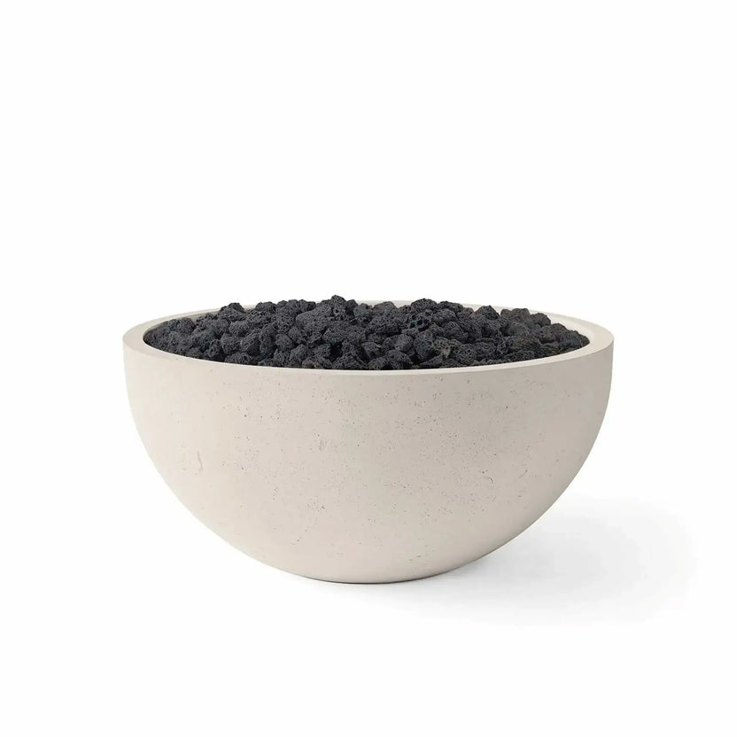 HPC Fire Hearth Products Controls Dekko GFRC Concrete Serenade 32 Fire Pit finished in Clay with black lava rock fire media. The bowl-shaped GFRC concrete fire pit features a soft beige exterior, broad fire media opening, and rugged volcanic lava rocks that create natural texture and contrast. Product image isolated on a white background, highlighting the modern design for outdoor entertainment and patio fire features.