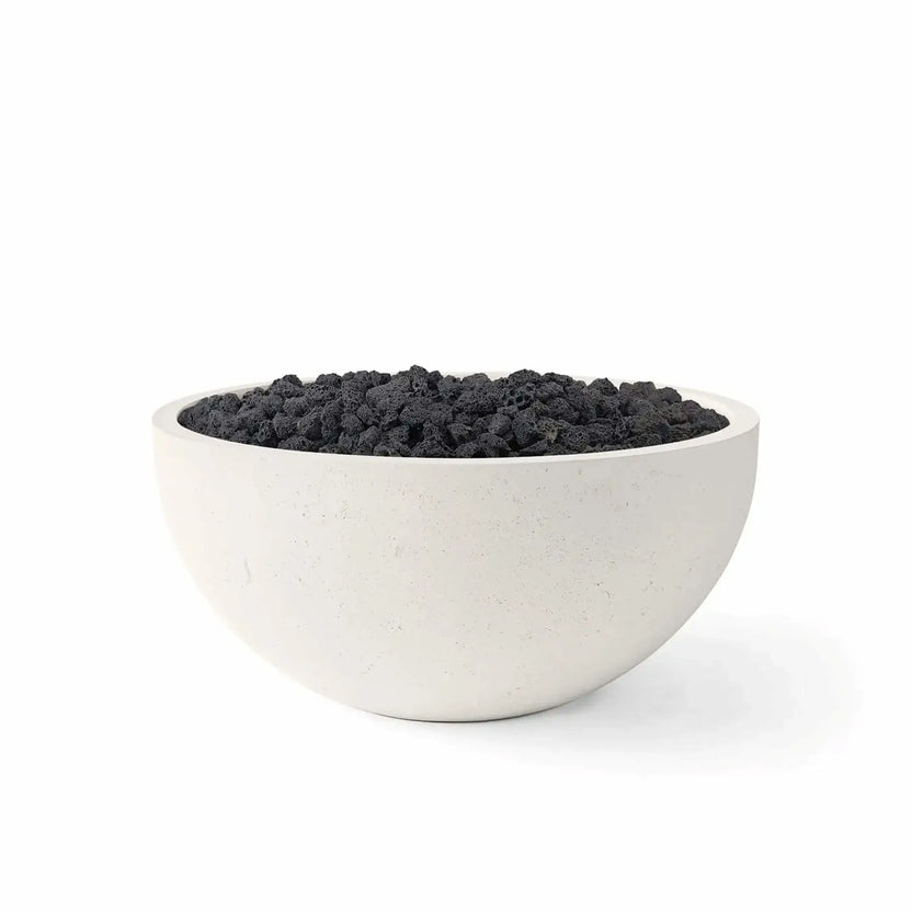 HPC Fire Hearth Products Controls Dekko GFRC Concrete Serenade 32 Fire Pit in Limestone finish with Lava Rock media. The rounded concrete fire bowl features a light limestone-toned exterior contrasted by rugged black lava rock, creating a bold and contemporary fire feature appearance. This studio product image on a white background showcases the available media and finish options for the Serenade 32 Fire Pit.