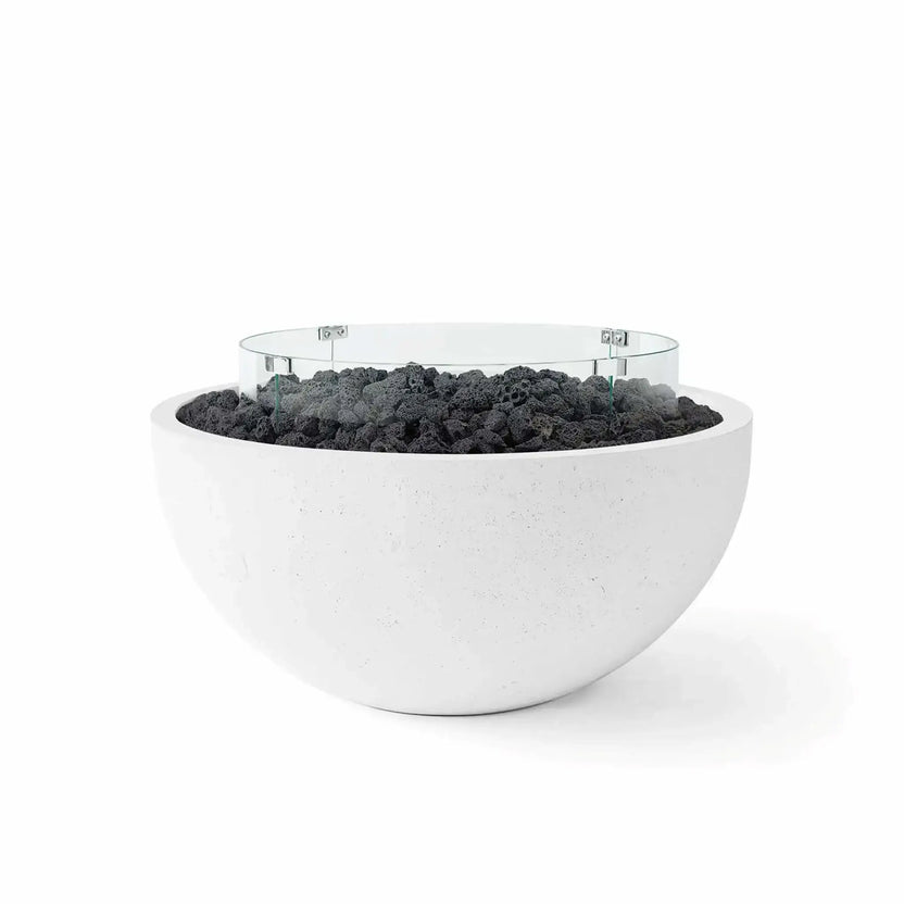 HPC Fire Hearth Products Controls Dekko GFRC Concrete Serenade 32 Fire Pit in Natural finish with black lava rock media and a tempered glass wind guard. This contemporary outdoor fire bowl highlights durable GFRC concrete construction, a rounded minimalist design, and rugged volcanic rock fill that adds texture and contrast to patios, outdoor lounges, and modern backyard settings.