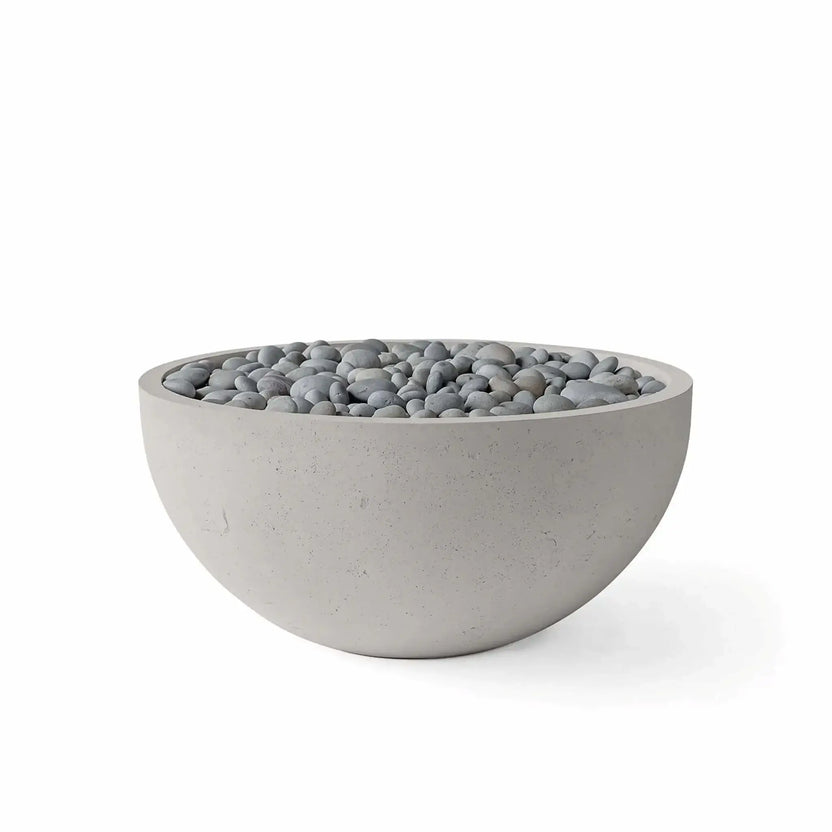 HPC Fire Hearth Products Controls Dekko GFRC Concrete Serenade 32 Fire Pit in Sandstone finish with Slate Stone media. The bowl-shaped GFRC concrete fire pit showcases a soft sandstone-toned exterior filled with smooth gray slate stones, offering a refined blend of natural textures and modern design. Presented on a white background, this product image emphasizes the Serenade 32 Fire Pit’s durable construction, rounded silhouette, and versatile slate stone media option for upscale patio and backyard installa
