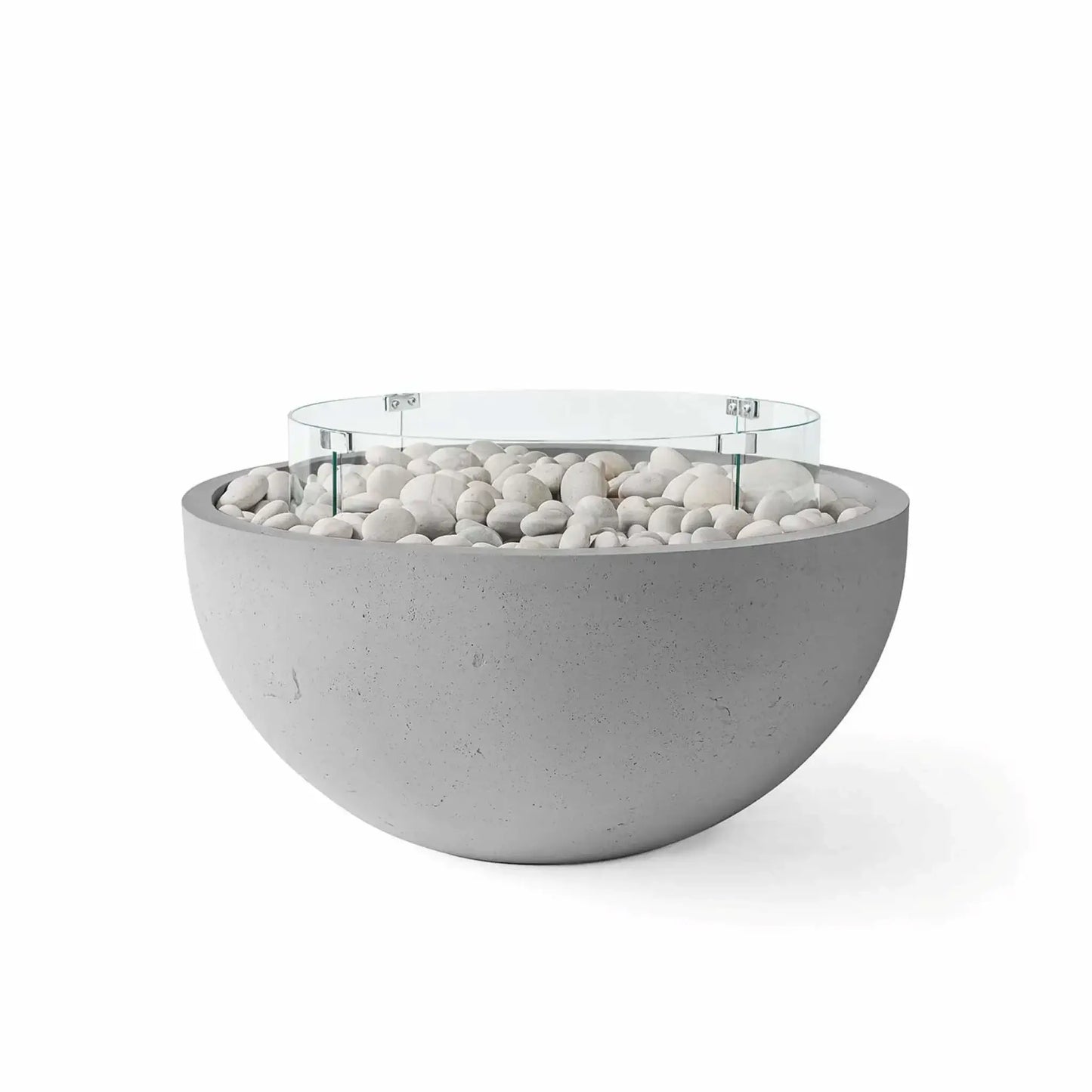 HPC Fire Hearth Products Controls Dekko GFRC Concrete Serenade 40 Fire Pit in Charcoal finish featuring ivory stone fire media and a tempered glass wind guard. The sleek round fire pit combines a dark charcoal concrete bowl with bright white decorative stones and a circular glass flame barrier, offering a striking contrast that complements contemporary outdoor seating areas and luxury landscape designs.