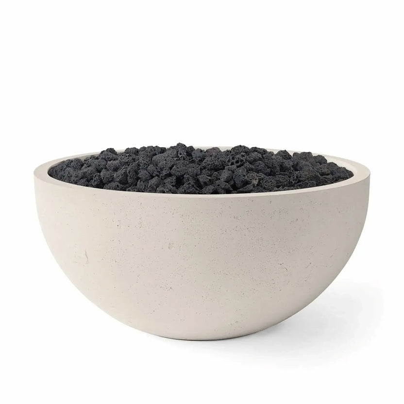 HPC Fire Hearth Products Controls Dekko GFRC Concrete Serenade 40 Fire Pit in Clay finish filled with black lava rock. This modern round GFRC concrete fire bowl features a warm beige exterior, durable concrete construction, and rugged volcanic fire media. Clean studio photography highlights the contrast between the light clay finish and dark lava rock, creating a stylish outdoor centerpiece for patios and entertaining spaces.