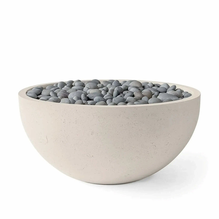 HPC Fire Hearth Products Controls Dekko GFRC Concrete Serenade 40 Fire Pit in Clay finish with slate stone media. The round fire bowl showcases a warm beige GFRC concrete exterior, smooth curved profile, and decorative gray slate stones covering the burner opening. Product image emphasizes the contemporary outdoor fire pit aesthetic, durable construction, and versatile design suitable for residential patios and landscape projects.