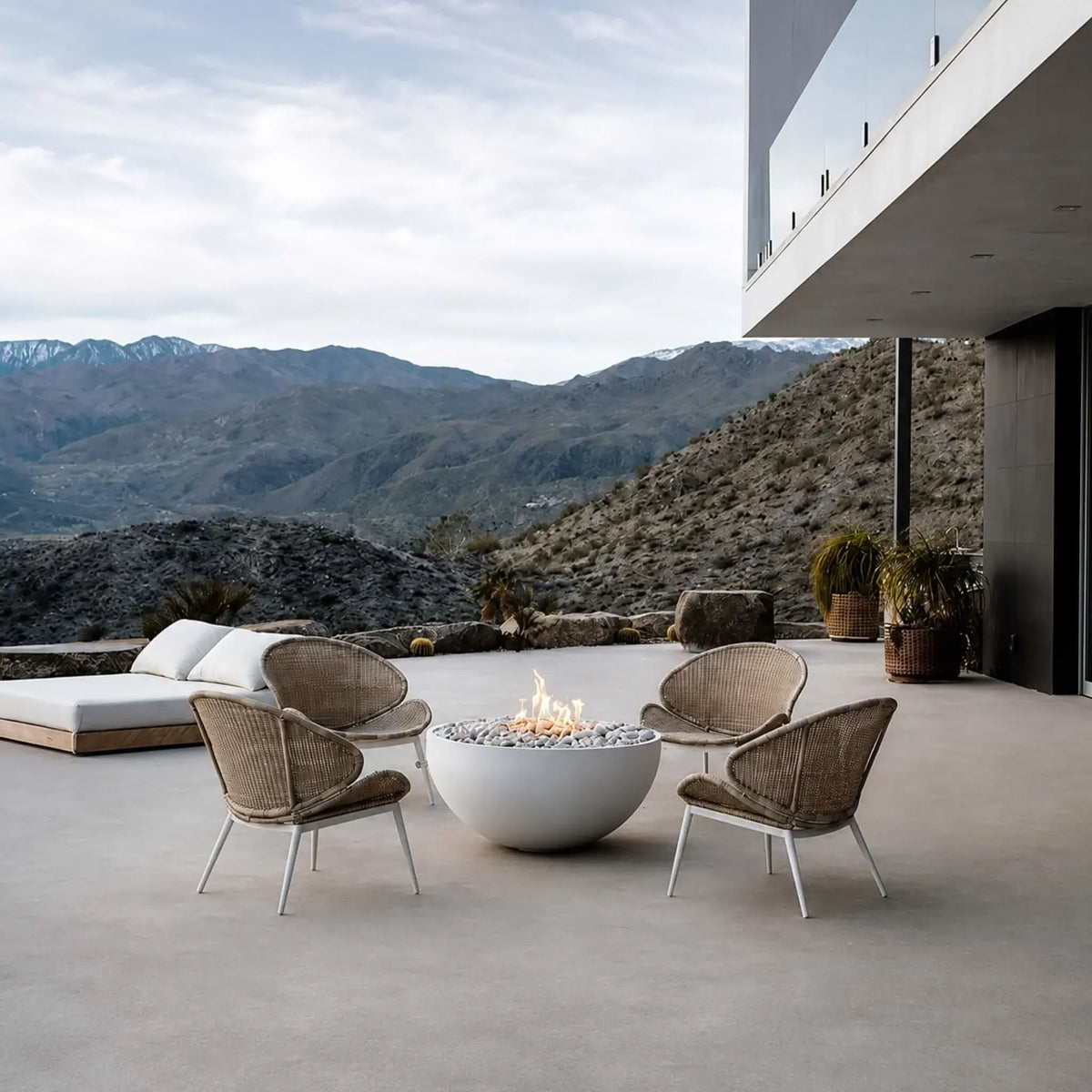 HPC Fire Hearth Products Controls Dekko GFRC Concrete Serenade 40 Fire Pit Lifestyle image showcasing a modern desert home with a white round Serenade 40 fire pit centered beside a reflective swimming pool. A couple relaxes around the glowing fire feature on a minimalist patio, highlighting the fire pit’s contemporary GFRC concrete construction, clean lines, and ability to create a warm outdoor gathering space in a luxury residential setting.