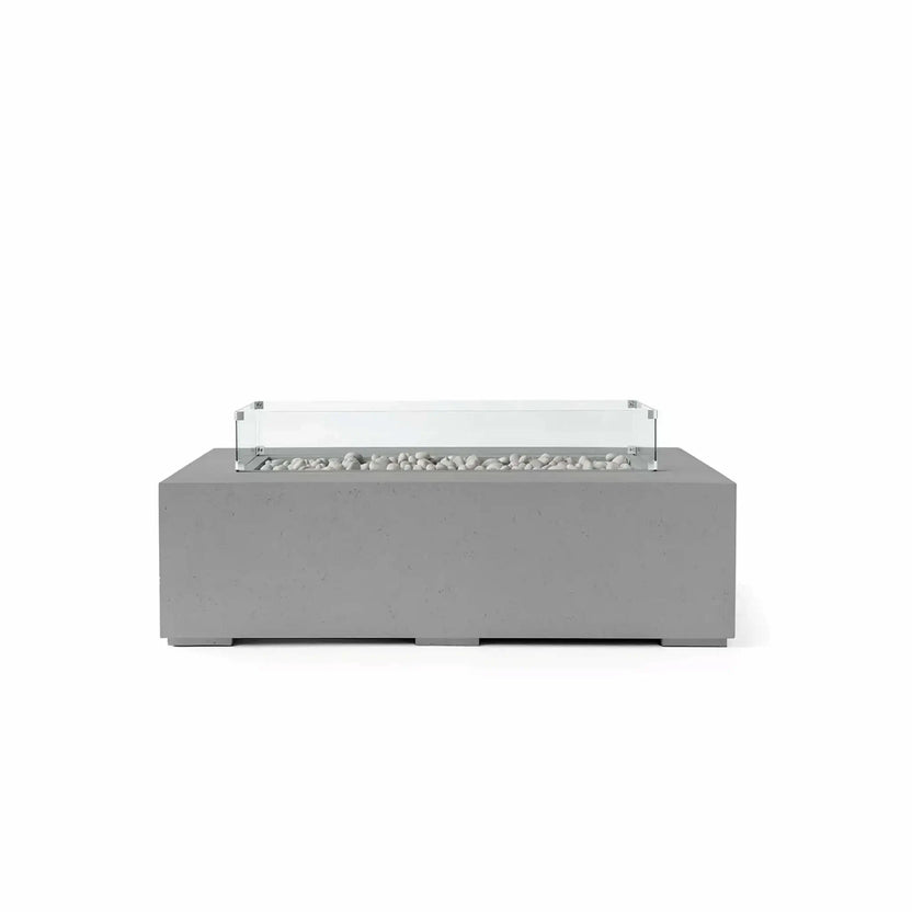 HPC Fire Hearth Products Controls Dekko GFRC Concrete Sonoma 56 x 30 Fire Pit in Charcoal finish featuring Ivory Stone media and a tempered glass wind guard. The dark charcoal concrete exterior contrasts beautifully with the smooth ivory fire stones inside the linear burner tray. A transparent glass wind guard surrounds the burner area, creating a refined modern aesthetic that complements luxury patios, rooftop lounges, and contemporary outdoor living environments.