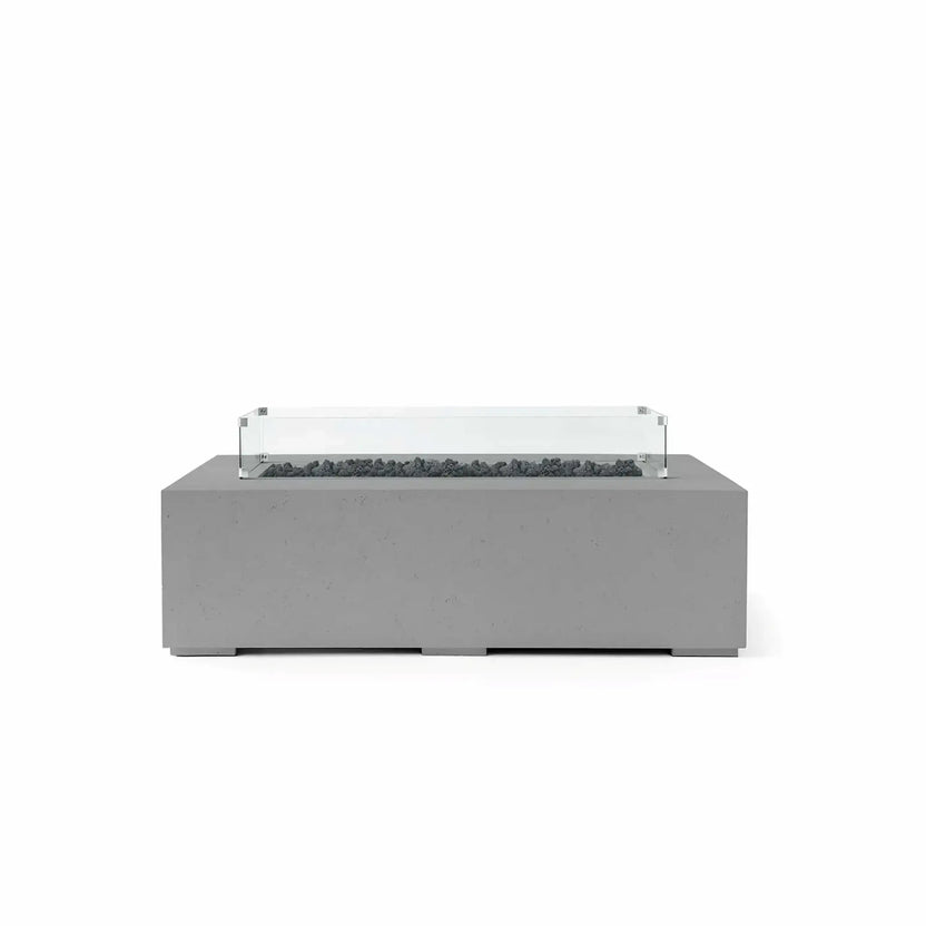 HPC Fire Hearth Products Controls Dekko GFRC Concrete Sonoma 56 x 30 Fire Pit finished in Charcoal with black Lava Rock media and a tempered glass wind guard. This modern rectangular fire pit features a textured GFRC concrete body, recessed linear burner opening, and rugged volcanic rock that blends seamlessly with the charcoal finish. The clear glass wind guard provides added flame protection while enhancing the fire pit’s clean, contemporary design.