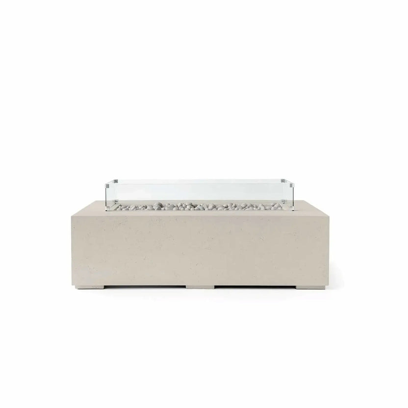 HPC Fire Hearth Products Controls Dekko GFRC Concrete Sonoma 56 x 30 Fire Pit in Clay finish featuring Ivory Stone media and a tempered glass wind guard. This rectangular outdoor fire table combines a warm clay-colored GFRC concrete exterior with smooth ivory stones arranged inside the recessed burner opening. The clear glass wind guard adds protection without obstructing the view, creating an elegant focal point for patios, courtyards, and outdoor lounge areas.