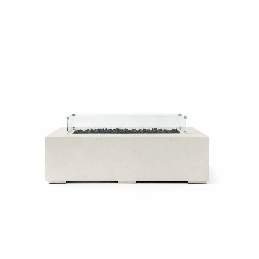 HPC Fire Hearth Products Controls Dekko GFRC Concrete Sonoma 56 x 30 Fire Pit in a light Limestone finish featuring black Lava Rock media and a tempered glass wind guard. The rectangular GFRC concrete fire pit showcases a modern linear burner design with rugged volcanic rock, clean architectural lines, and a transparent wind guard that helps shield flames while maintaining an unobstructed view. Ideal for contemporary patios, poolside seating areas, and outdoor entertaining spaces.