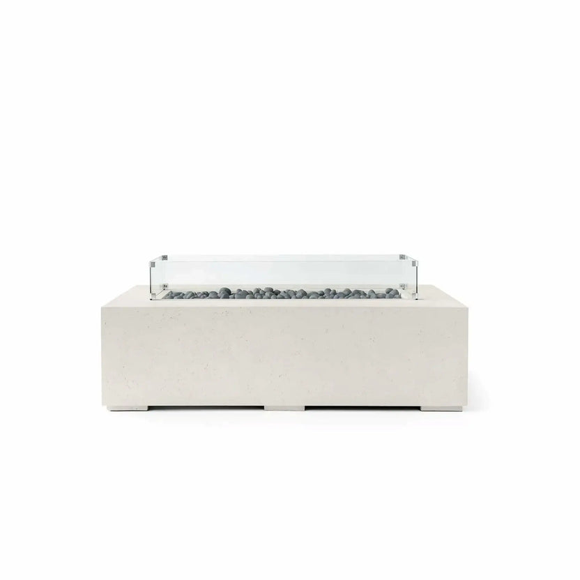 HPC Fire Hearth Products Controls Dekko GFRC Concrete Sonoma 56 x 30 Fire Pit in Limestone finish with Slate Stone fire media and a tempered glass wind guard. This contemporary rectangular fire pit features durable GFRC concrete construction, a recessed linear burner filled with smooth gray slate stones, and a clear glass wind guard for enhanced flame protection. The soft limestone tone and minimalist design complement modern outdoor living environments.