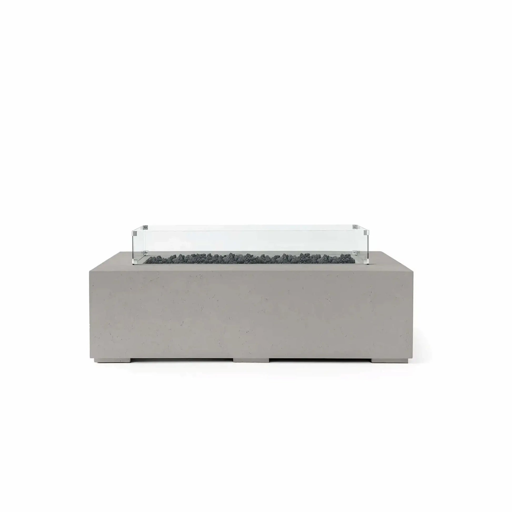 HPC Fire Hearth Products Controls Dekko GFRC Concrete Sonoma 56 x 30 Fire Pit in Sandstone finish featuring black Lava Rock media and a tempered glass wind guard. This rectangular outdoor fire pit combines a warm sandstone GFRC concrete body with dark volcanic lava rock inside the recessed burner channel, creating strong visual contrast. The transparent glass wind guard completes the sophisticated design while helping protect flames from outdoor breezes.