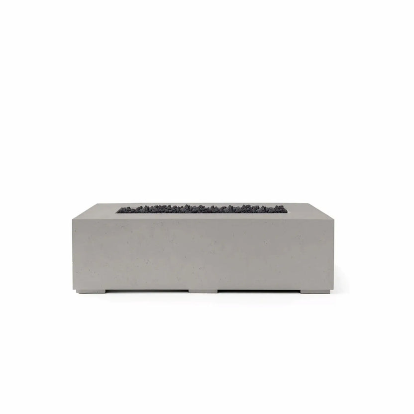 HPC Fire Hearth Products Controls Dekko GFRC Concrete Sonoma 56 x 30 Fire Pit finished in Sandstone with black Lava Rock burner media. The rectangular Sonoma fire pit features a textured GFRC concrete exterior, broad tabletop edge, and a recessed burner channel filled with dark volcanic rock for striking visual contrast. Shown in a clean product image, this contemporary outdoor fire feature is designed for modern patios, courtyards, and backyard gathering areas.