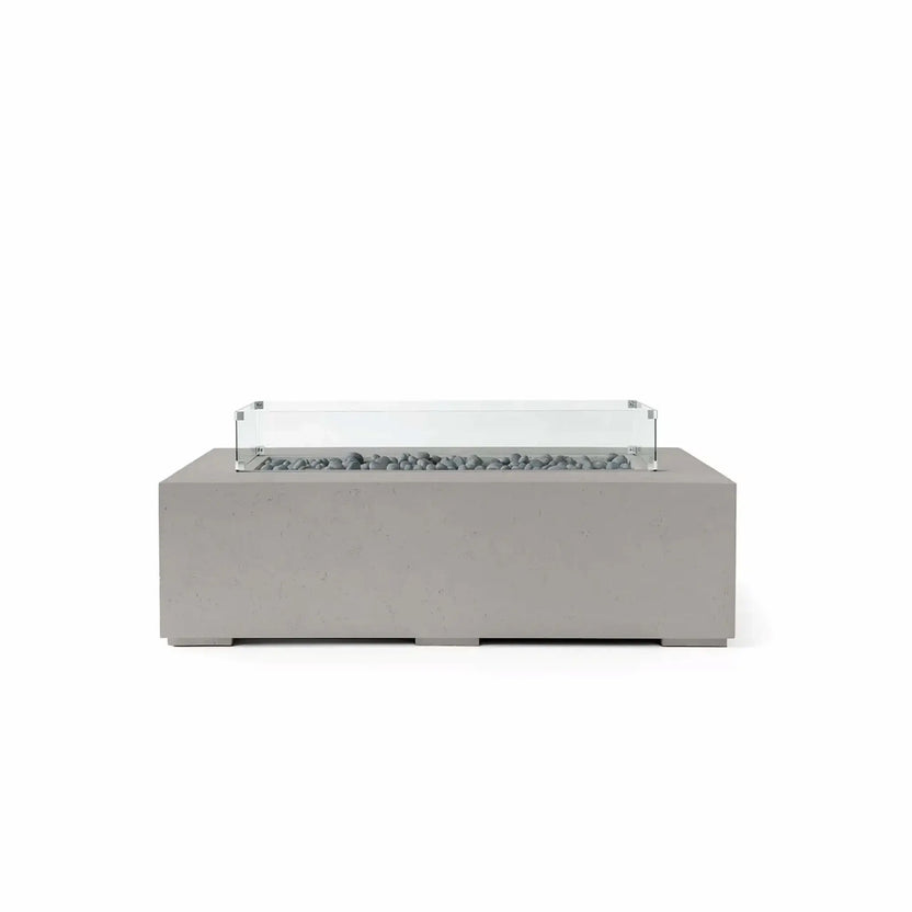 HPC Fire Hearth Products Controls Dekko GFRC Concrete Sonoma 56 x 30 Fire Pit in Sandstone finish with Slate Stone media and a tempered glass wind guard. The rectangular fire pit features durable GFRC concrete construction, decorative gray slate stones within the linear burner opening, and a clear wind guard mounted above the fire area. Its warm sandstone tone and modern silhouette make it a stylish centerpiece for patios, terraces, and outdoor conversation spaces.