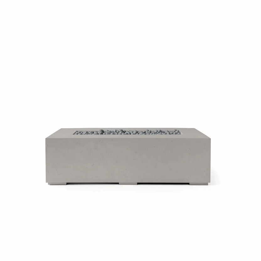 HPC Fire Hearth Products Controls Dekko GFRC Concrete Sonoma 56 x 30 Fire Pit in Sandstone finish with Slate Stone media. This modern rectangular outdoor fire pit features durable glass fiber reinforced concrete construction, a recessed linear burner opening, and decorative gray slate stones that complement the warm sandstone tone. Displayed on a white background, the Sonoma fire pit offers a refined contemporary aesthetic ideal for outdoor living rooms, patios, and luxury landscape designs.