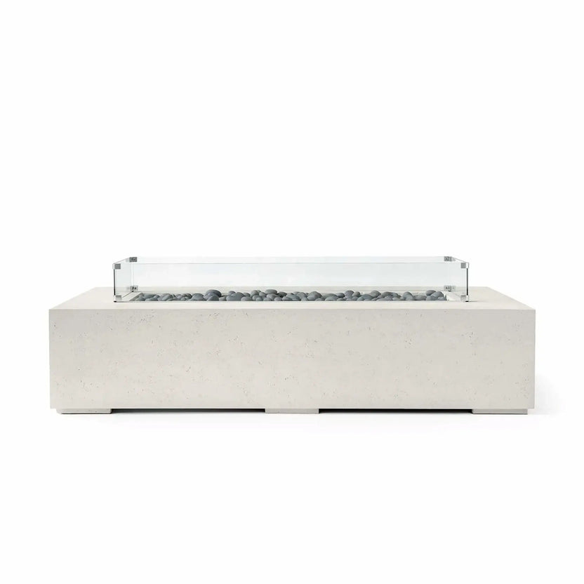 HPC Fire Hearth Products Controls Dekko GFRC Concrete Sonoma 72 x 33 Fire Pit in Limestone finish with smooth gray slate stone fire media and a tempered glass wind guard. The elongated rectangular design combines modern aesthetics with durable concrete construction, creating an elegant outdoor centerpiece for contemporary patios, poolside seating areas, and upscale entertainment spaces.