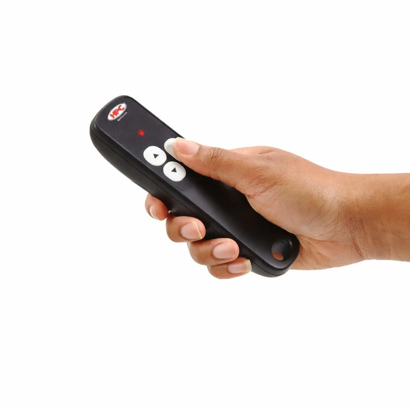 HPC Fire Hearth Products Controls EI Hi Low adjustable flame control remote with hand holding the device, demonstrating real-world use of the wireless remote to ignite and adjust flame height on a gas fire pit with ergonomic design and simple push-button controls.