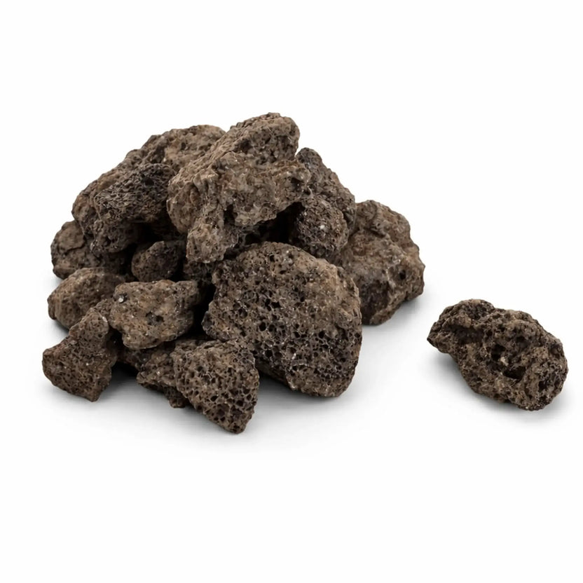 Close-up of lava rock pieces with one stone separated from the pile, highlighting the rough, porous surface and natural variation in size and color, isolated on a white background for product display and fire pit media use.