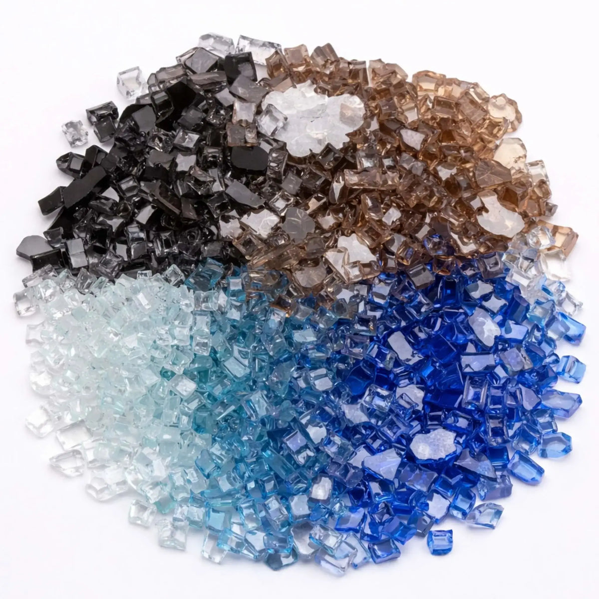 A neatly arranged display of tempered fire glass in multiple colors including black, bronze, clear, cobalt blue, Pacific blue, and copper. The reflective, irregularly shaped glass pieces are grouped by color on a clean white background, showcasing the variety and visual contrast ideal for customizing gas fire pits and fireplaces.