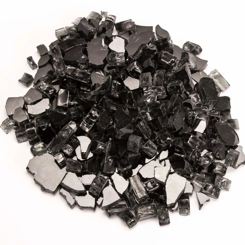 Close-up of non-reflective black tempered fire glass pieces scattered on a white background. The glass features a mix of angular shards and smooth edges with a glossy charcoal finish, offering a bold, modern look for fire pit burners and fireplace media.