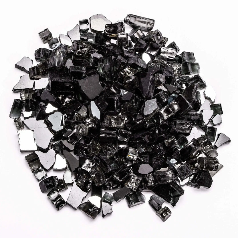 Close-up of reflective black tempered fire glass pieces scattered in a mound on a white background. The sharp-edged fragments feature a glossy finish with mirror-like backing, creating depth and shimmer. Perfect for contemporary fire pits or fireplaces where a bold, sleek, and dramatic flame presentation is desired.