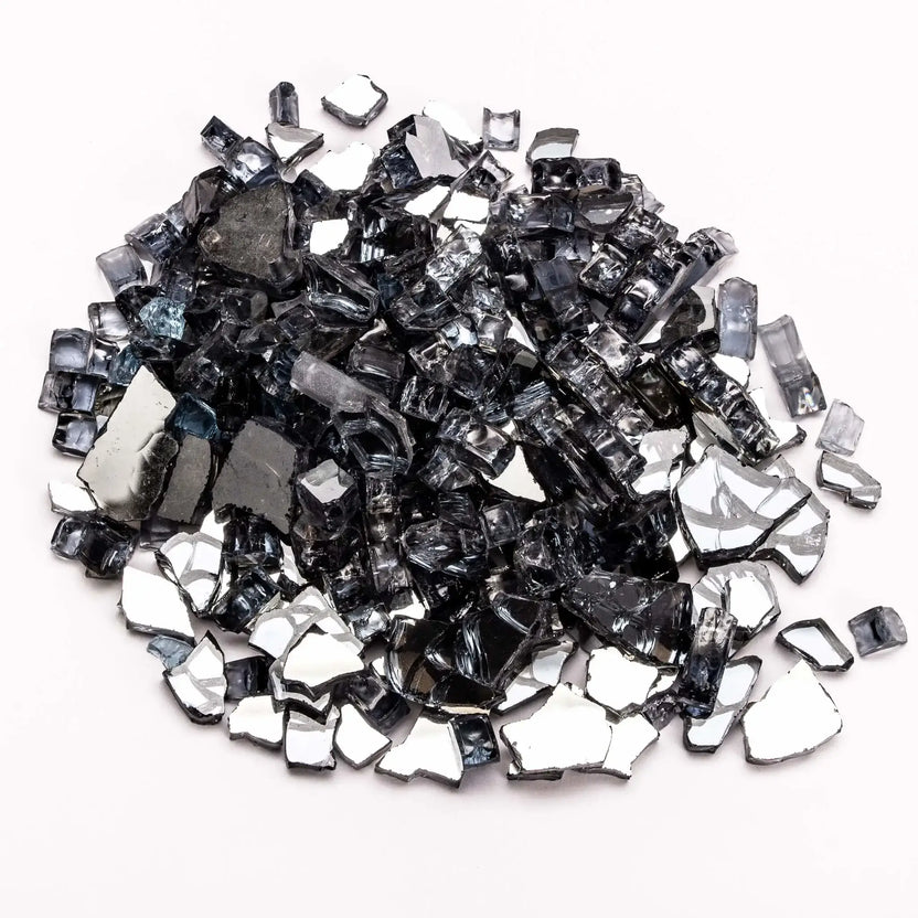 A pile of reflective gray tempered fire glass with a smoky, translucent appearance, shown on a white background. The irregular, polished pieces reflect light subtly, blending silver and charcoal tones. This fire glass offers a modern, neutral look that enhances flame visibility while maintaining a clean, upscale aesthetic.