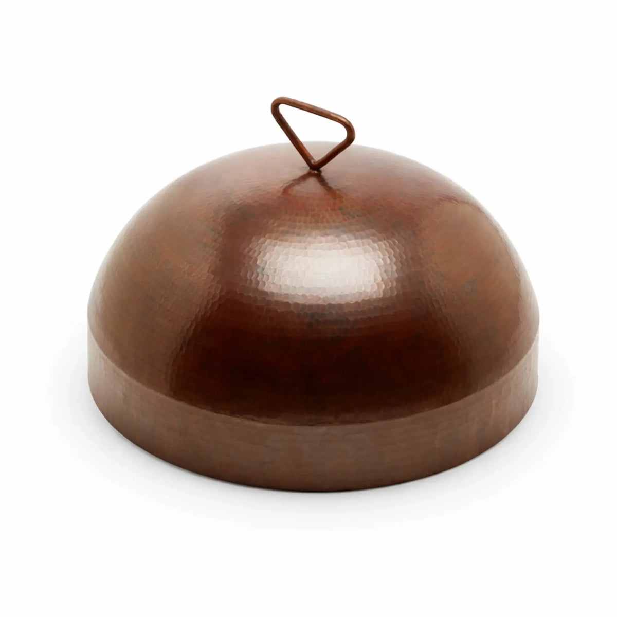 Close-up of a hammered copper Mesa fire pit burner cover with a domed lid and loop handle, set on a wide circular rim. The warm copper tones and hand-hammered texture create a high-end, artisan look. Shot on a white background to clearly showcase the smooth curvature, reflective finish, and detailed craftsmanship of the round cover.