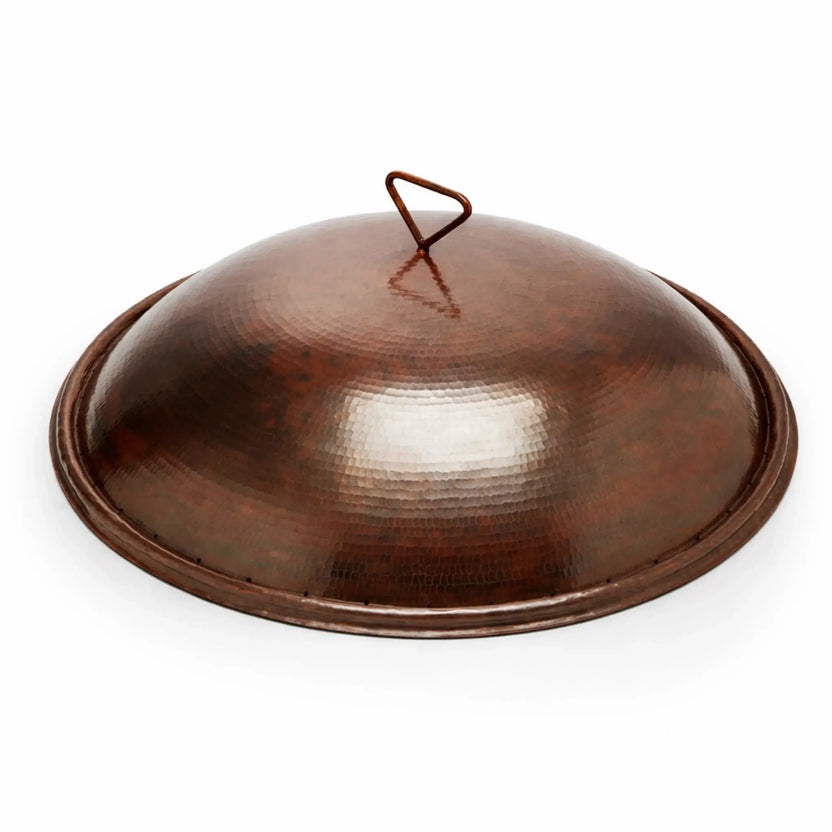 Standalone hammered copper round burner cover for a Tempe fire bowl, showcasing a smooth domed lid with a loop handle and a slightly flared base. The rich copper finish and subtle hammered detailing give it a handcrafted appearance, highlighted against a bright white background for a clean product presentation.