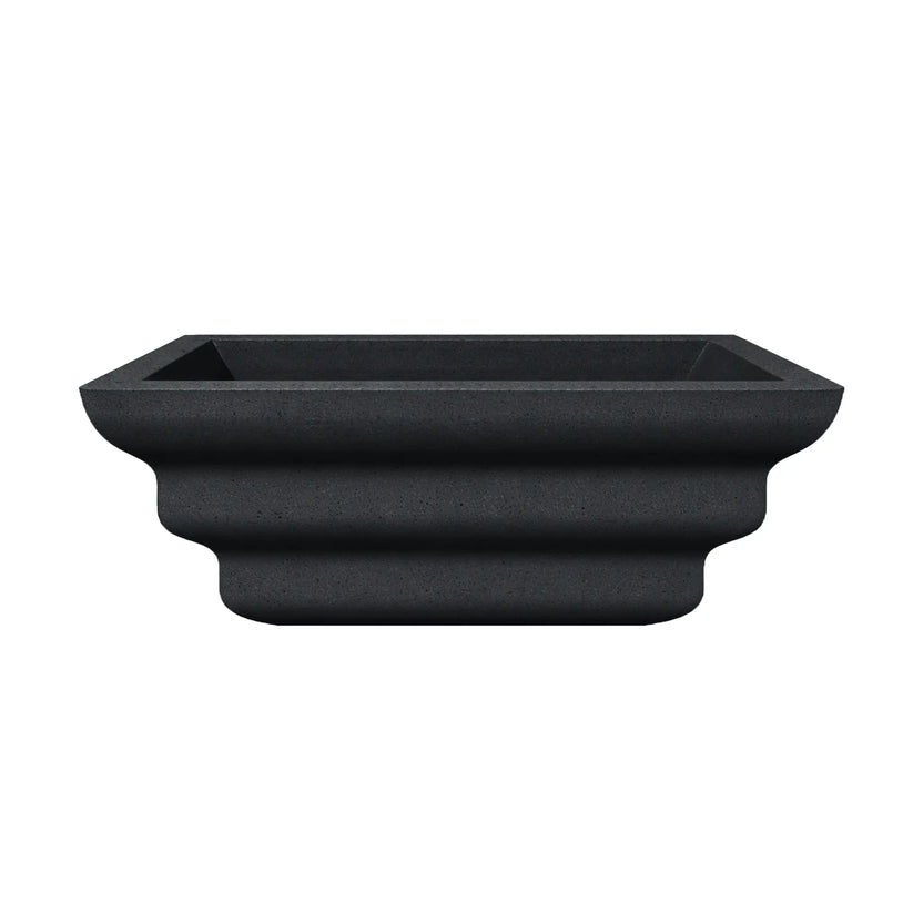 Side profile view of the black Shadow Cast Ripple Designer Series fire bowl with an empty basin. The sculpted ripple-style exterior creates layered curves that give the bowl a distinctive architectural look. The square rim and tapered base highlight the bowl’s modern outdoor fire feature design.